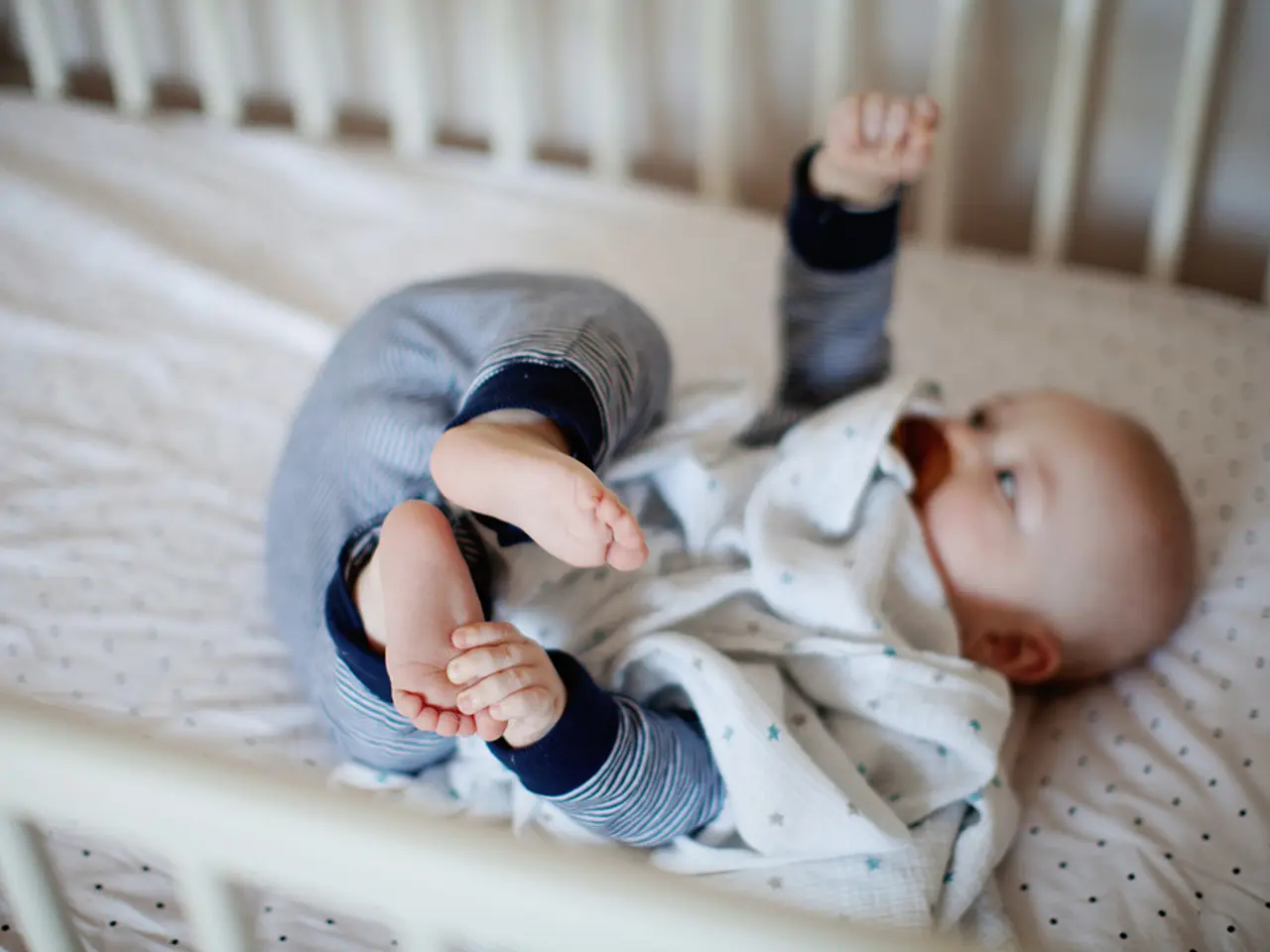 In this image we can see a baby is lying in the bed.