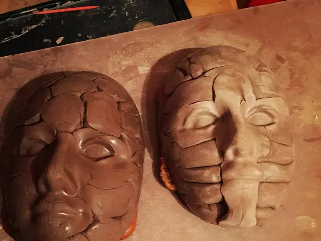 In this image I can see two masks one is in brown color and the other is in cream color on some...