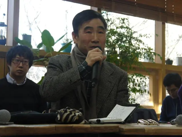 This image is clicked in a room. There are tables, plants. There are lamps on the left side and...