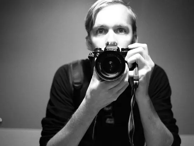 there is a man holding the camera.