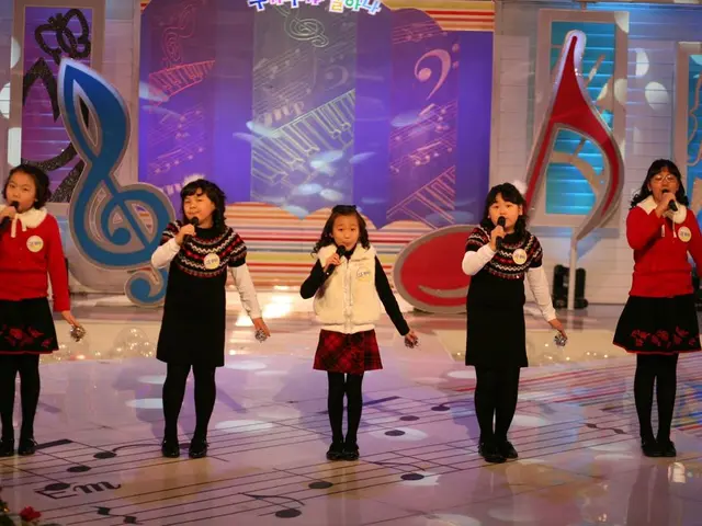 In this image we can see group of kids standing on stage and holding microphone in their hands and...