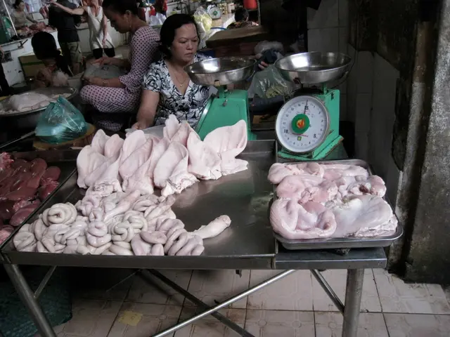 In the picture we can see a woman selling the meat sitting on the floor and inn front of her we can...