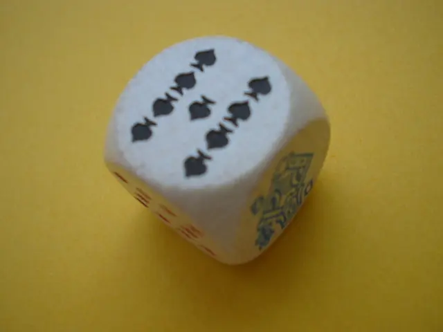 In this picture we can observe a white color dice. There are black and red color symbols on this...
