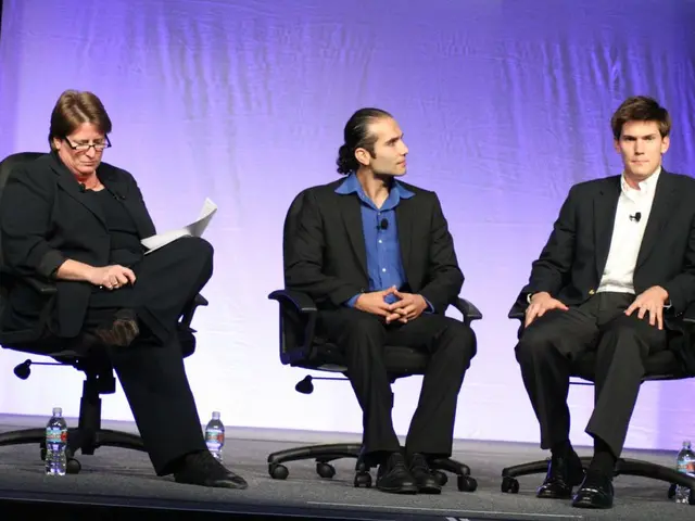 In this picture we can see three men, they are seated on the chairs, beside to them we can find few...